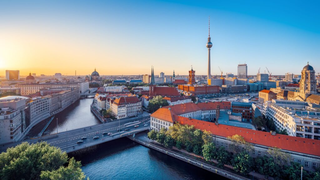 A panoramic view of Berlin’s skyline featuring the Brandenburg Gate and modern buildings.